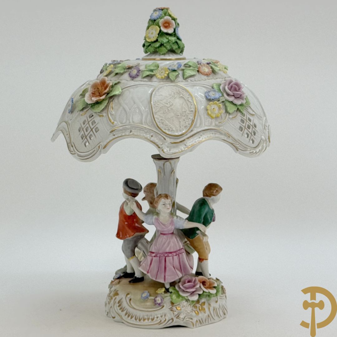 Porseleinen lampadaire met dansende figuren, bovenaan met porseleinen kap bezet met bloemmetjes