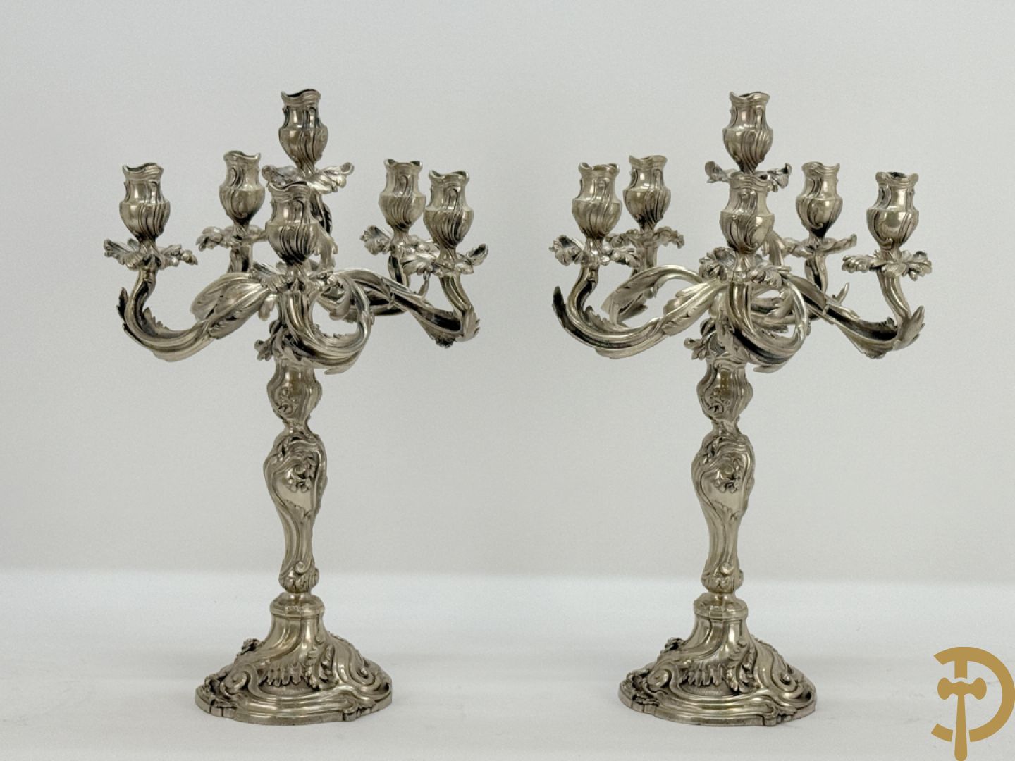 Paar massief zilveren getorste zesarmige kandelaars met Louis XV motieven, met import stempel 