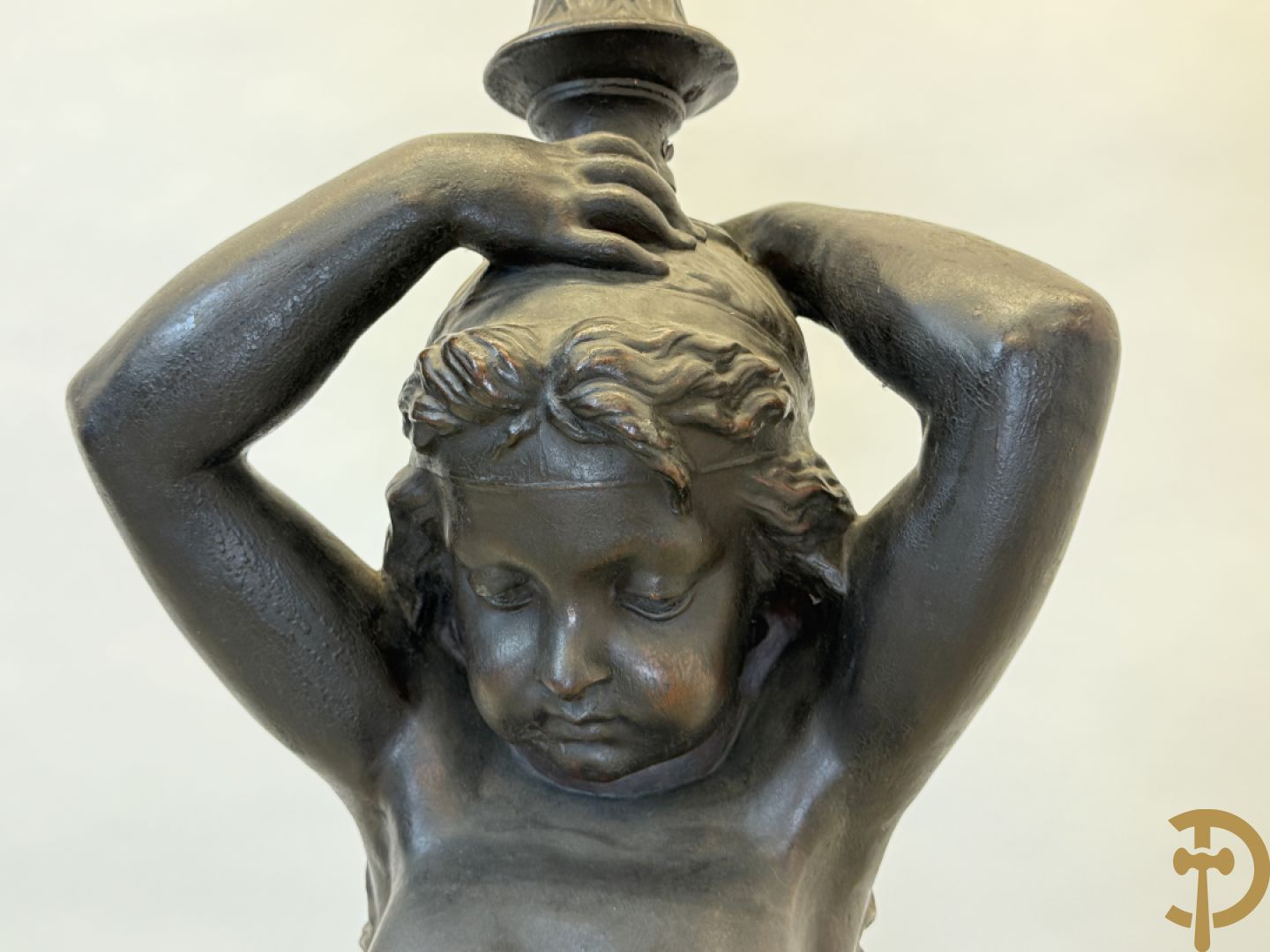Gietijzeren gepatineerd beeld van cupido dragende een amfoor op het hoofd als lantaarn