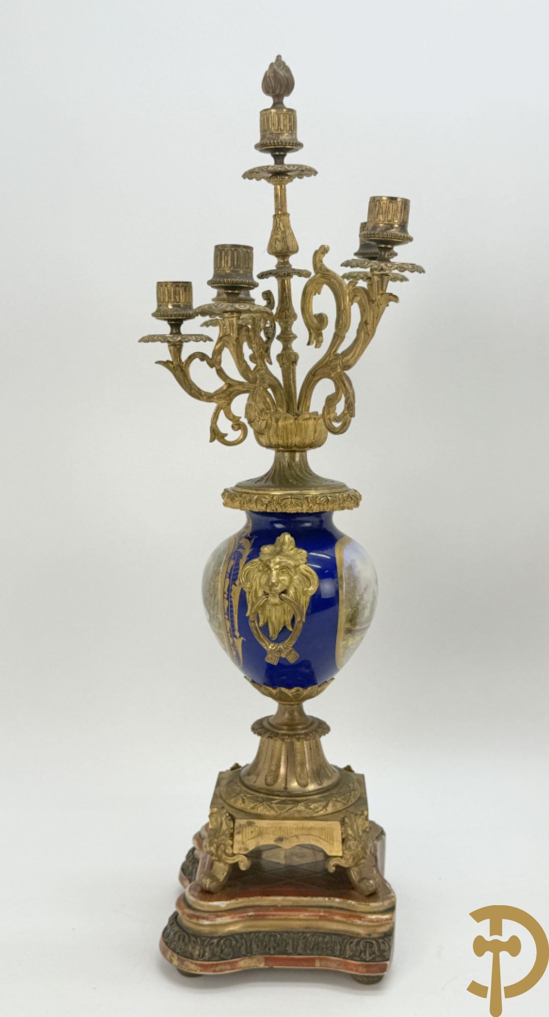 Driedelige vergulde bronzen garnituur bestaande uit pendule met blauw porseleinen coupe geflankeerd door 2 cupido