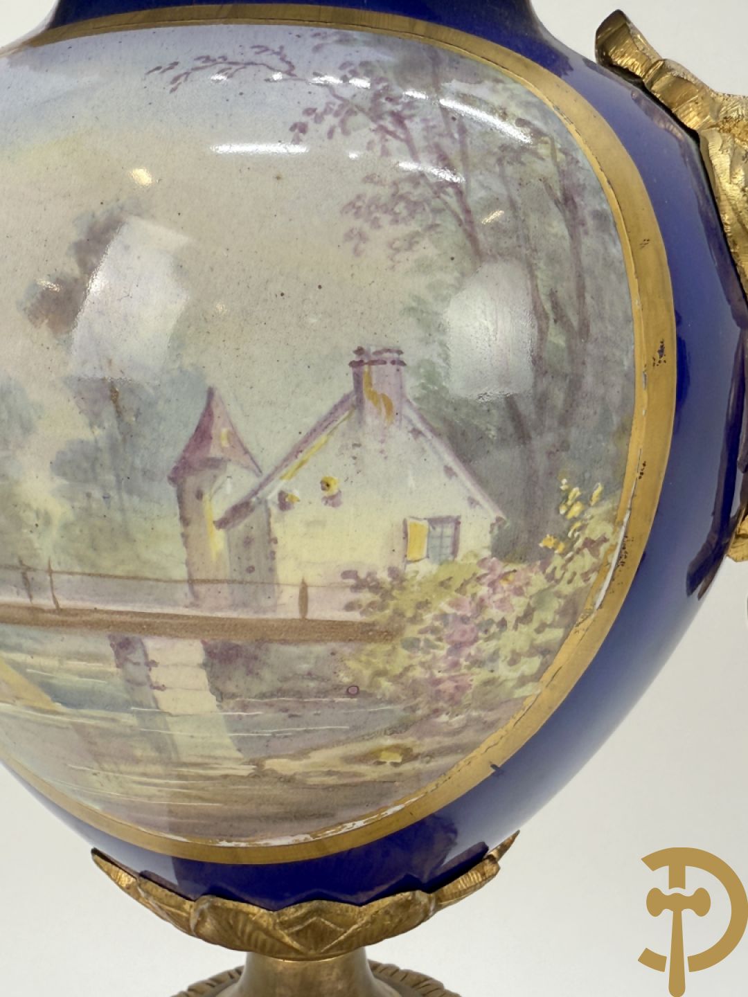 Driedelige vergulde bronzen garnituur bestaande uit pendule met blauw porseleinen coupe geflankeerd door 2 cupido