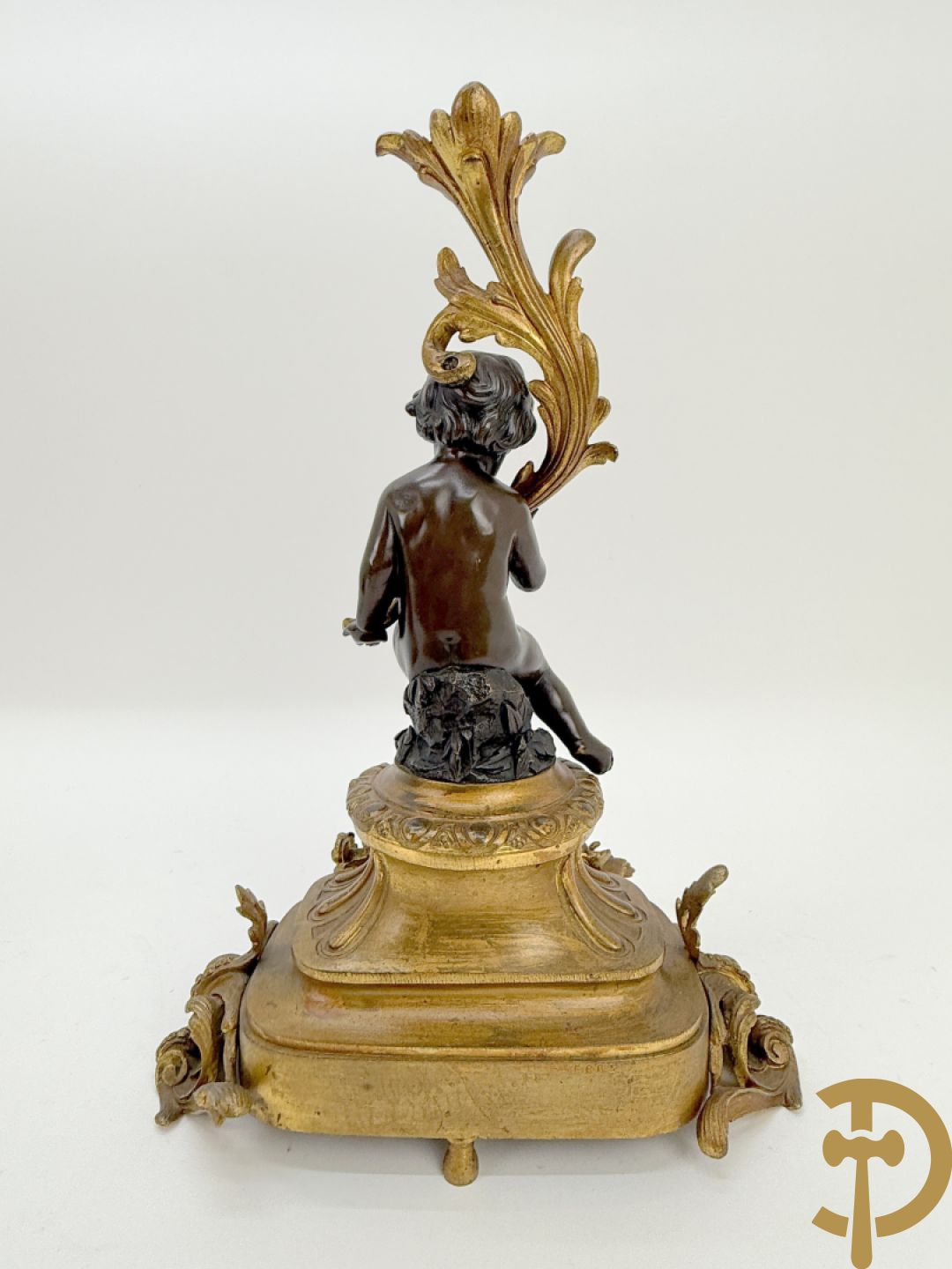 Driedelige bronzen garnituur bestaande uit middenstuk met bronzen vuurvergulde klok, Daubrée gemerkt à Nancy, bovenaan bekroond met Cleopatra met drinkbeker - getekend van Cumberworth sculpteur - geflankeerd door paar cupido