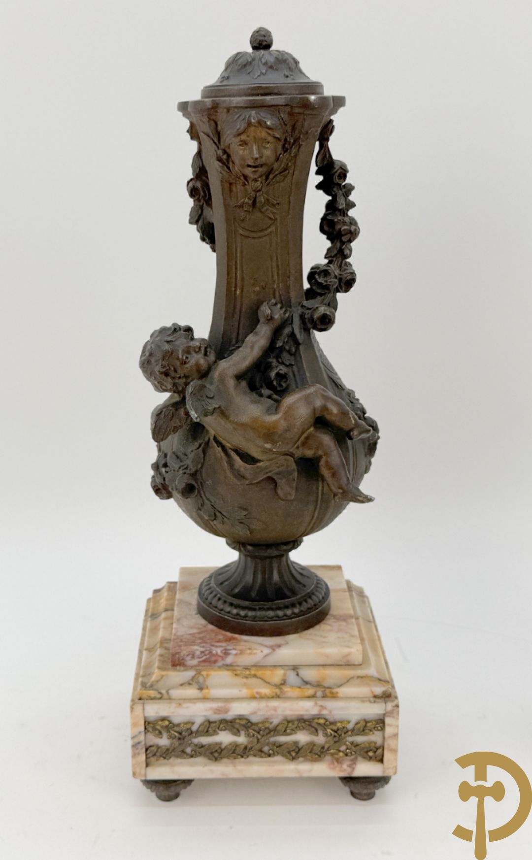 Driedelige kunstbronzen garnituur bestaande uit klok met liggende dame met amfoor op marmeren basis, geflankeerd door paar cassolettes met cupido