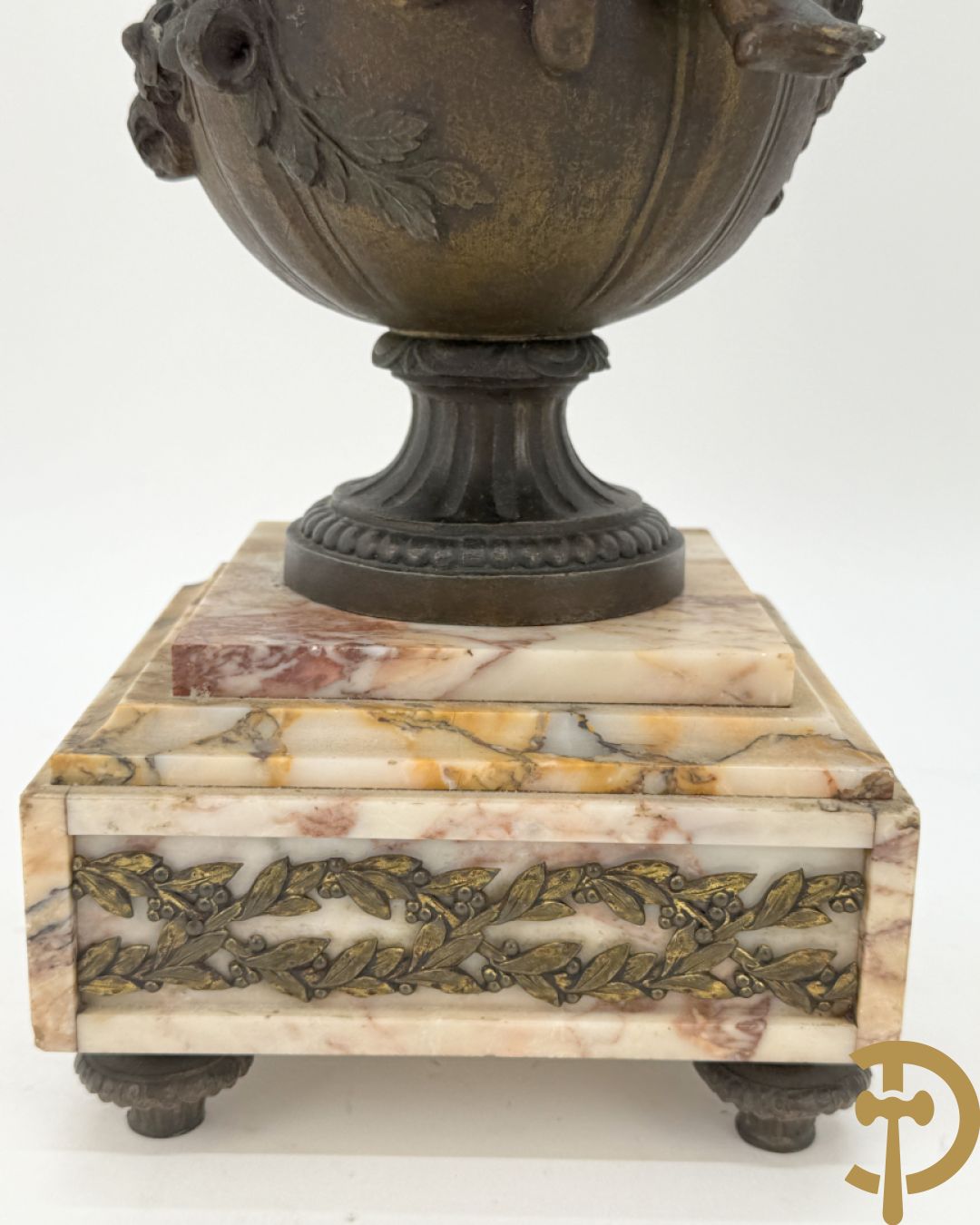 Driedelige kunstbronzen garnituur bestaande uit klok met liggende dame met amfoor op marmeren basis, geflankeerd door paar cassolettes met cupido