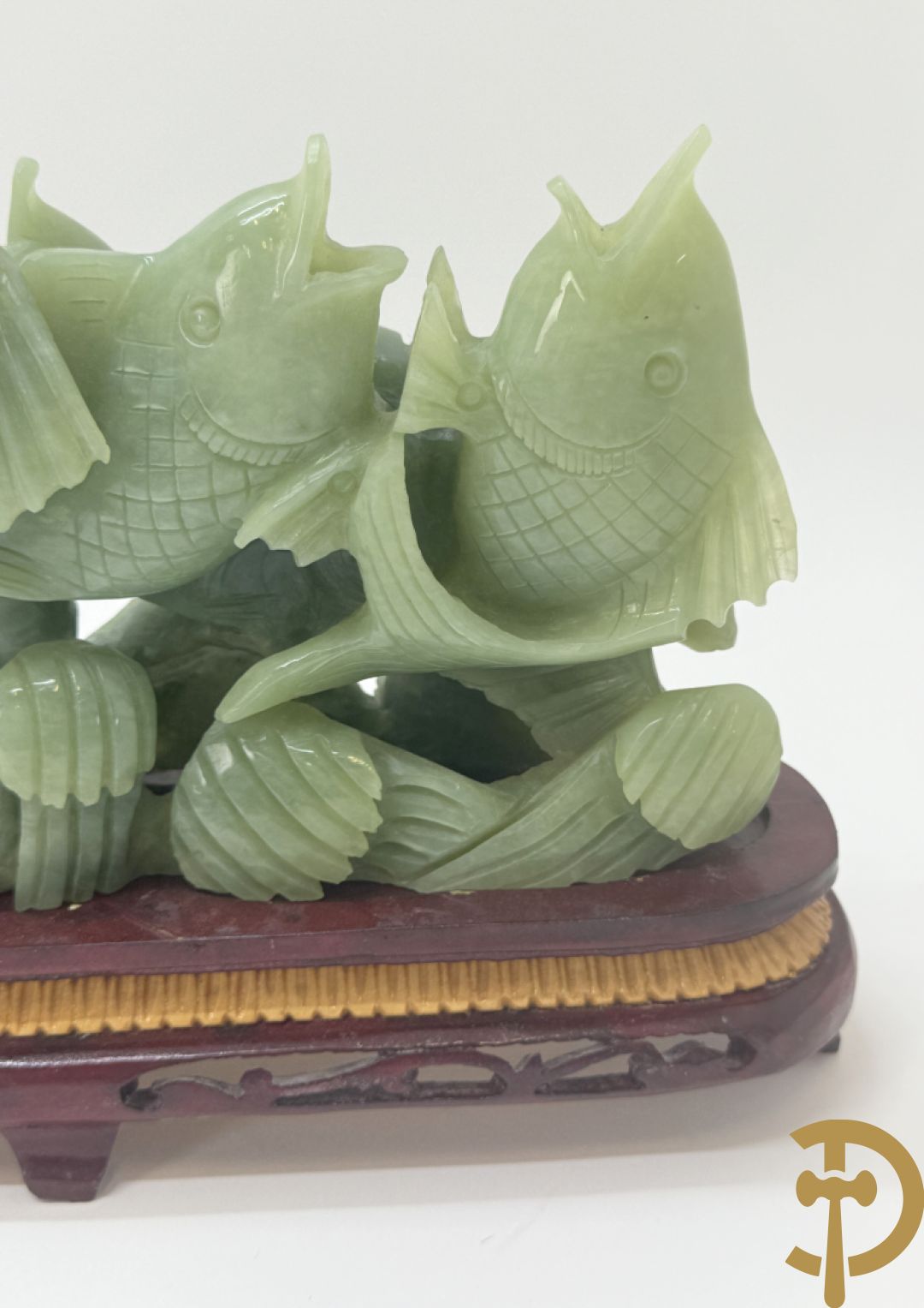 Sculptuur van vissen in jadeiet op houten sokkel