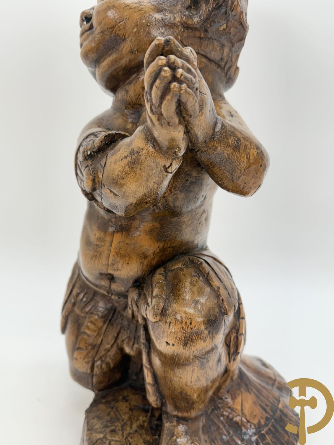 Houtgesculpteerde cupido met gevouwen handen en pluimen