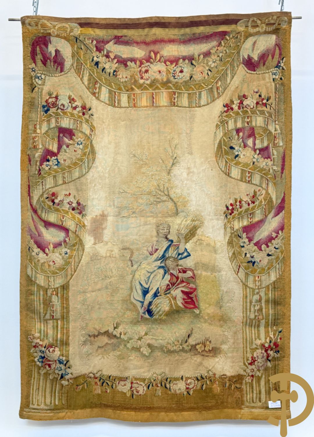 Handgeweven wandtapijt met centraal decor van dames in landschap met de oogst omgeven door bloemenguirlandes