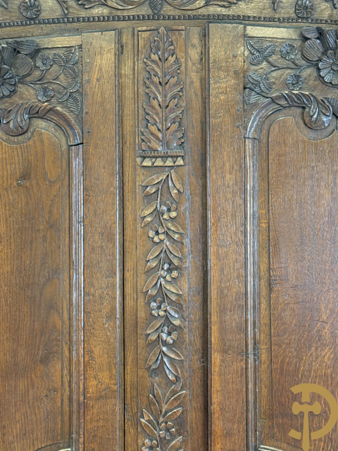 Massief eiken bruidskast met bloemensculptuur opzij, accanthusranken en bekroond met bloemenkorf