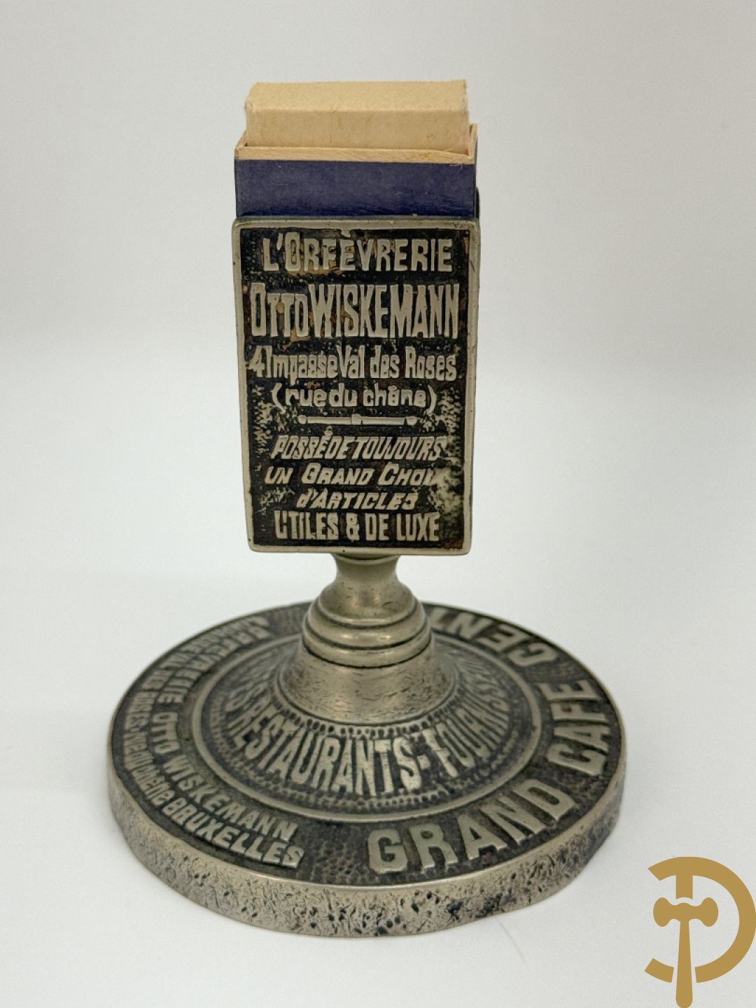 Vier luciferhouders in verzilverd metalen met reclame opschriften van Wiskeman (2 x) , Orfeverie Van Den Torren en Orfeverie L. Haut