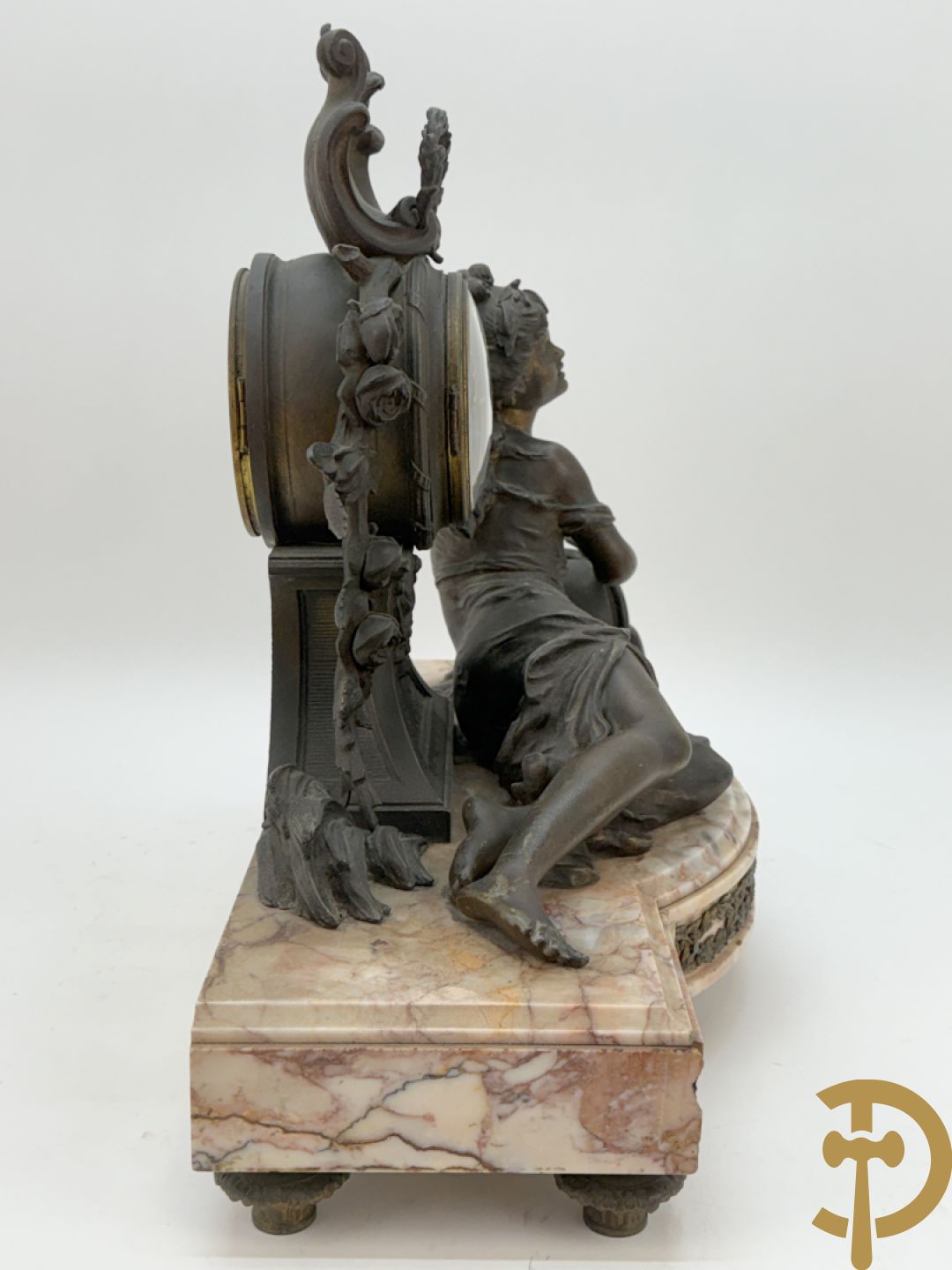 Driedelige kunstbronzen garnituur bestaande uit klok met liggende dame met amfoor op marmeren basis, geflankeerd door paar cassolettes met cupido