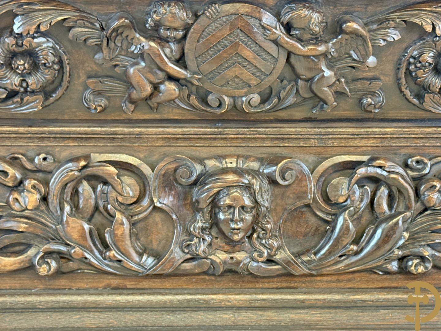 Tweedeursvitrine met Neo Renaissance sculptuur, bovenaan mlet cupidohoofden, bloemen en accanthusranken