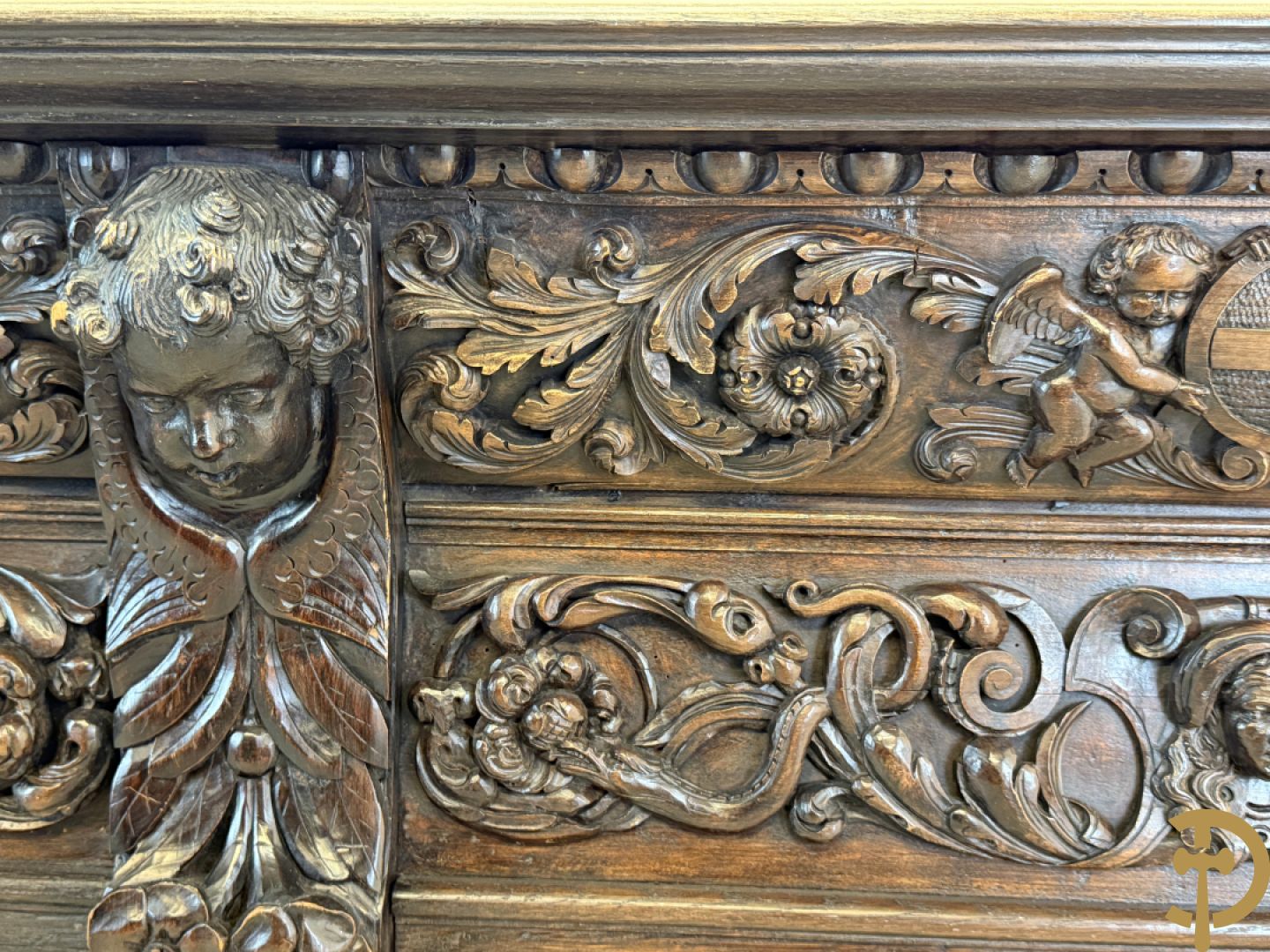 Tweedeursvitrine met Neo Renaissance sculptuur, bovenaan mlet cupidohoofden, bloemen en accanthusranken