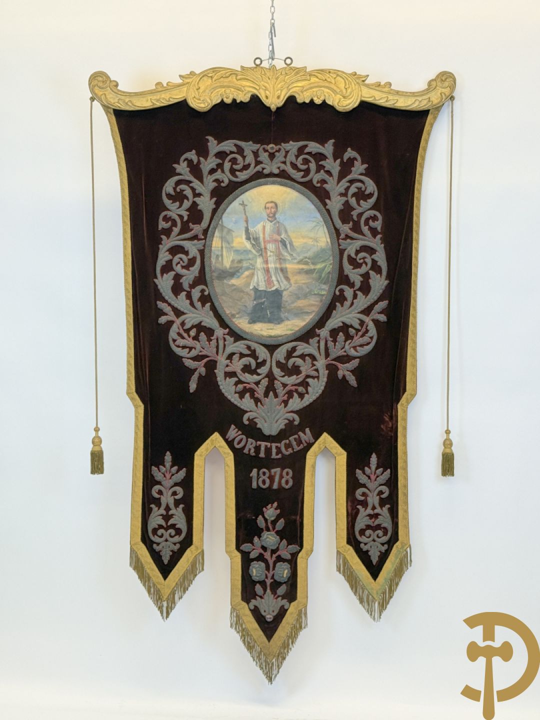 Processiebannier met bordeaux vaandel bezet met goudbrocaat van accanthusranken, Wortegem 1878, centraal handbeschilderd medaillon met voorstelling van Franciscus Xaverius - gehouden door verguld houtgesculpteerd ornament