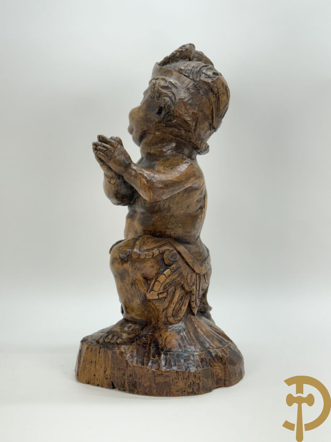 Houtgesculpteerde cupido met gevouwen handen en pluimen