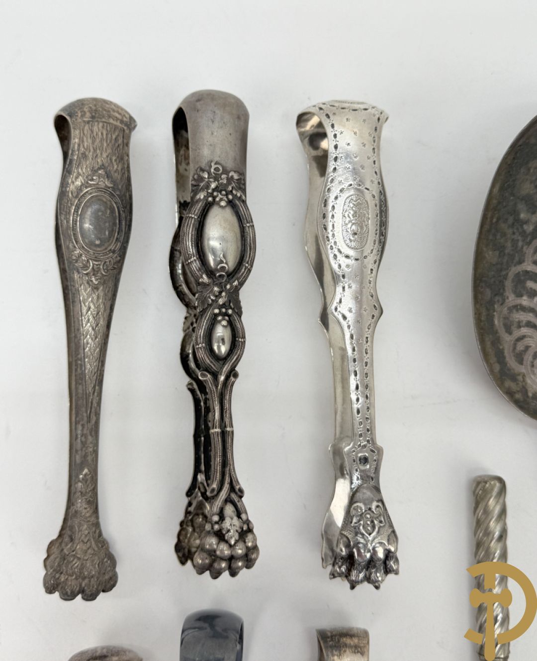 Drie massief zilveren suikertangen + 3 verzilverde suikertangen + lepel met Neo Renaissance motieven + mesje in houder