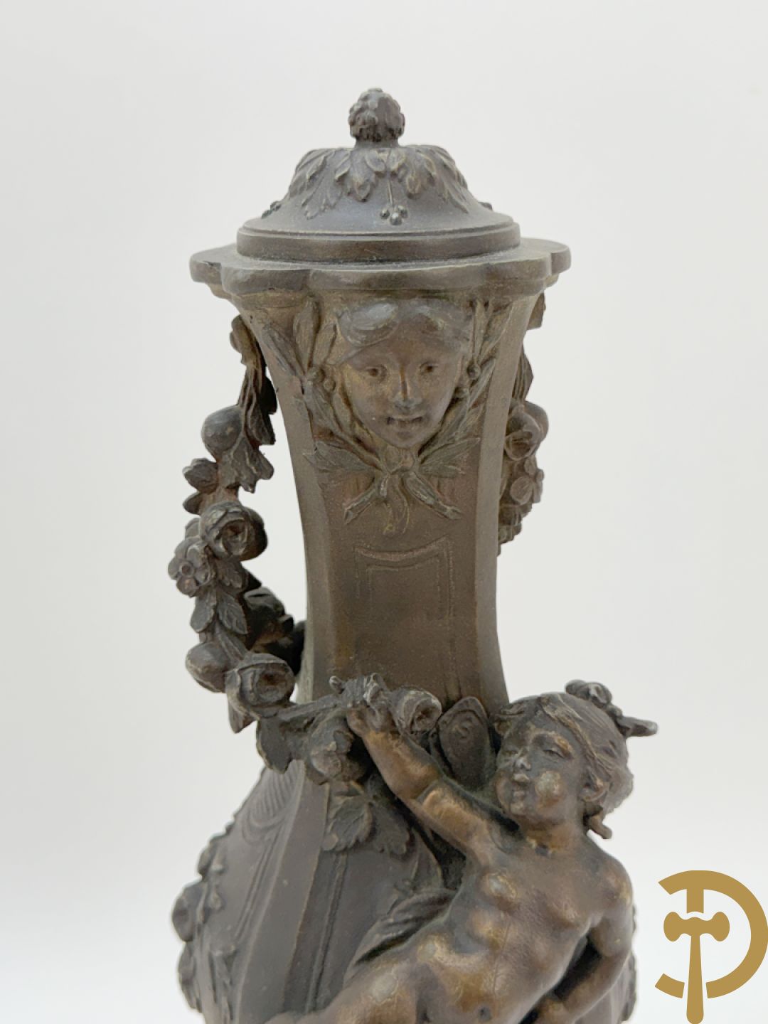 Driedelige kunstbronzen garnituur bestaande uit klok met liggende dame met amfoor op marmeren basis, geflankeerd door paar cassolettes met cupido