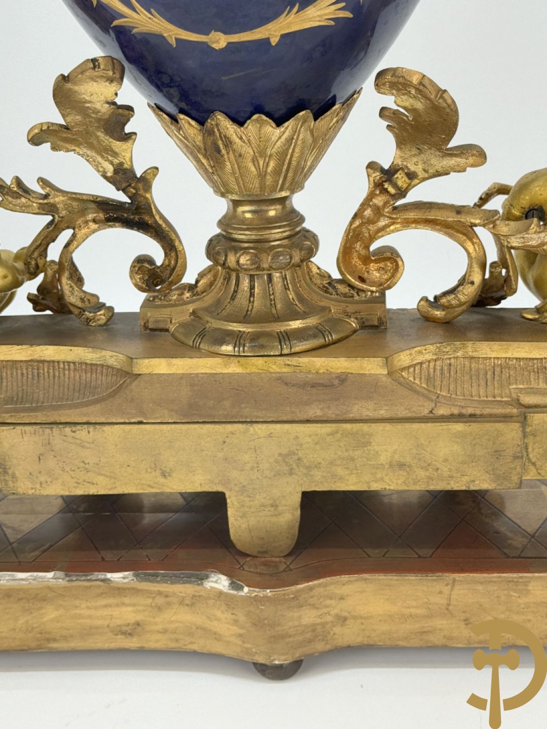 Driedelige vergulde bronzen garnituur bestaande uit pendule met blauw porseleinen coupe geflankeerd door 2 cupido
