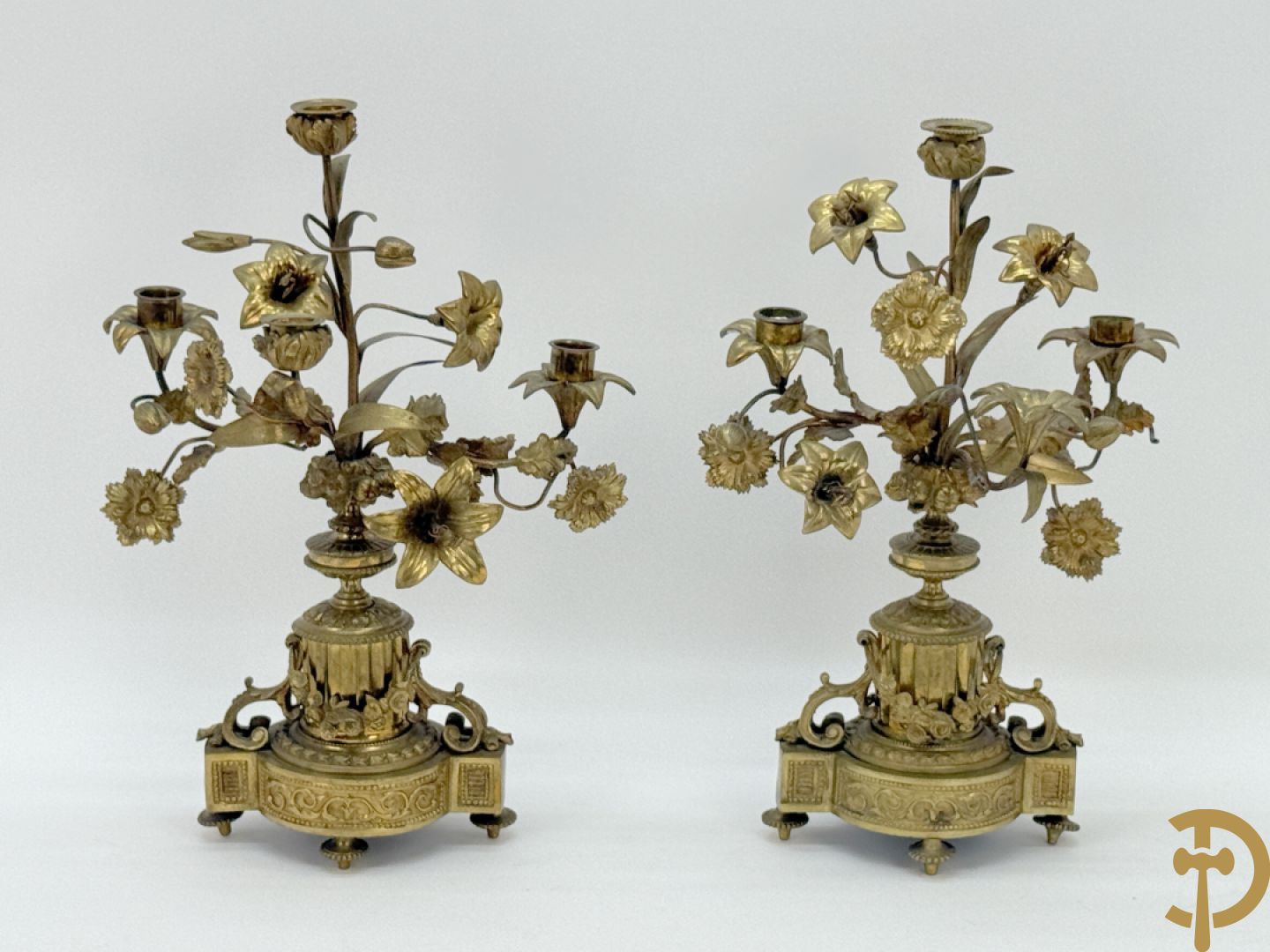Paar bronzen kandelaars met guirlande en bloemenmotieven