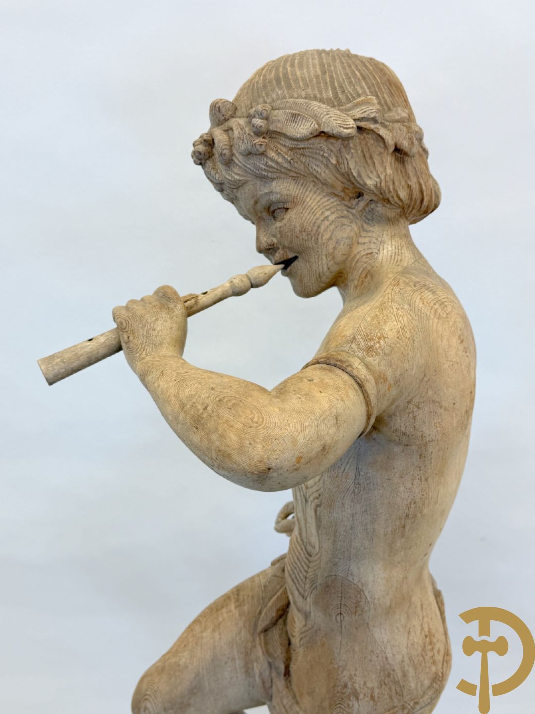 Houtgesculpteerde fluitspelende cupido staande op schelp