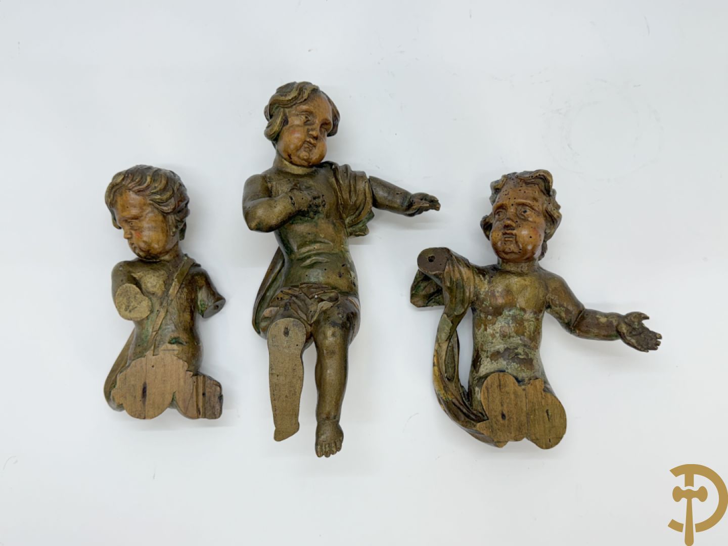 Drie houtgesculpteerde cupido