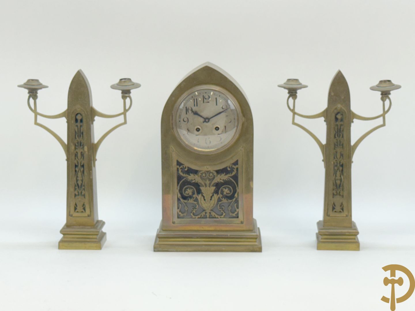 Driedelige koperen Art Nouveau garnituur bestaande uit kapelvormige pendule geflankeerd door paar kandelaars