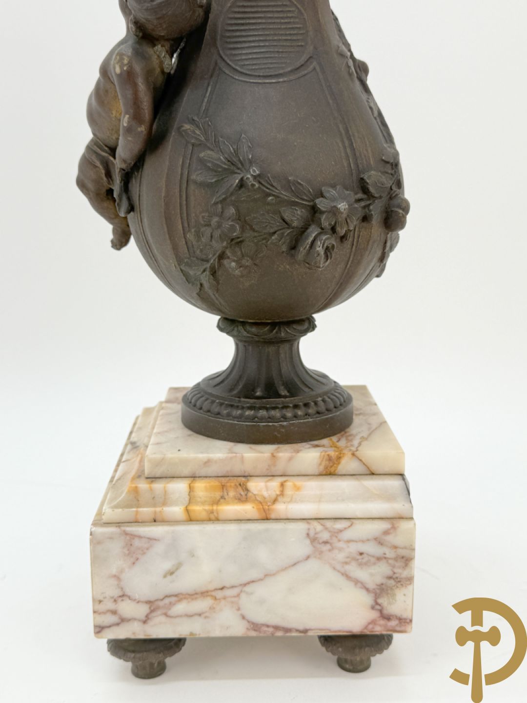 Driedelige kunstbronzen garnituur bestaande uit klok met liggende dame met amfoor op marmeren basis, geflankeerd door paar cassolettes met cupido