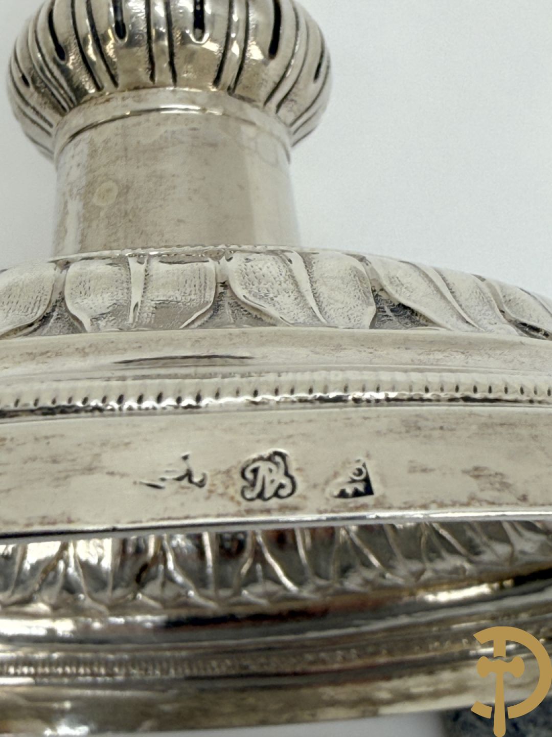 Paar massief zilveren kandelaars met gestyleerd bloemenmotief, één ervan gemerkt met stempel van Jan Baptist Verberckt, andere kandelaar met verschillende stempels met o.a. Antwerpen 1784