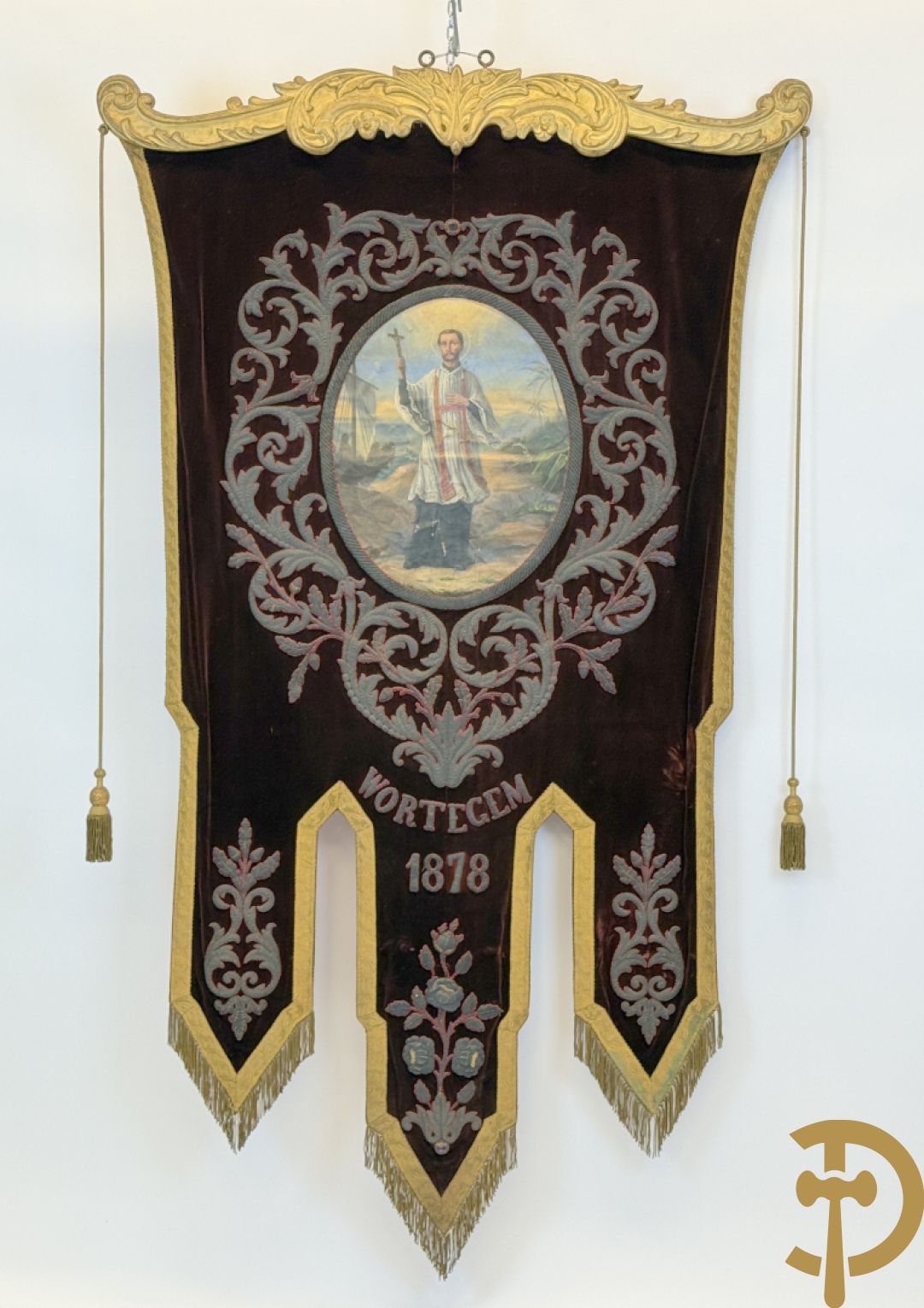 Processiebannier met bordeaux vaandel bezet met goudbrocaat van accanthusranken, Wortegem 1878, centraal handbeschilderd medaillon met voorstelling van Franciscus Xaverius - gehouden door verguld houtgesculpteerd ornament