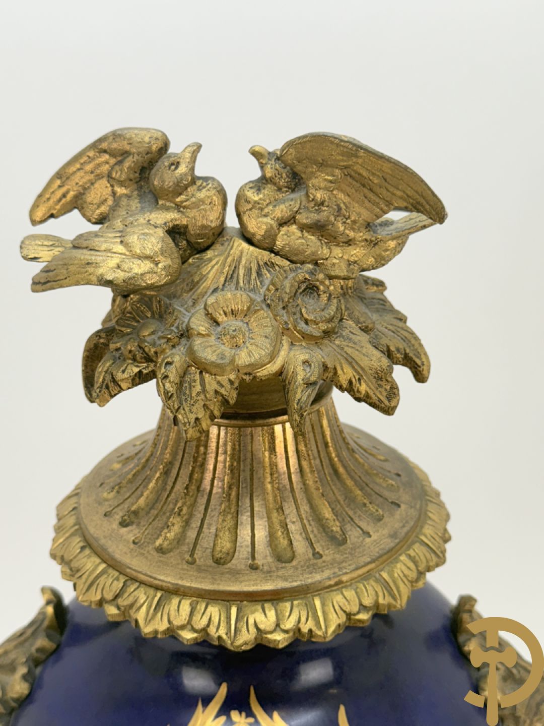 Driedelige vergulde bronzen garnituur bestaande uit pendule met blauw porseleinen coupe geflankeerd door 2 cupido