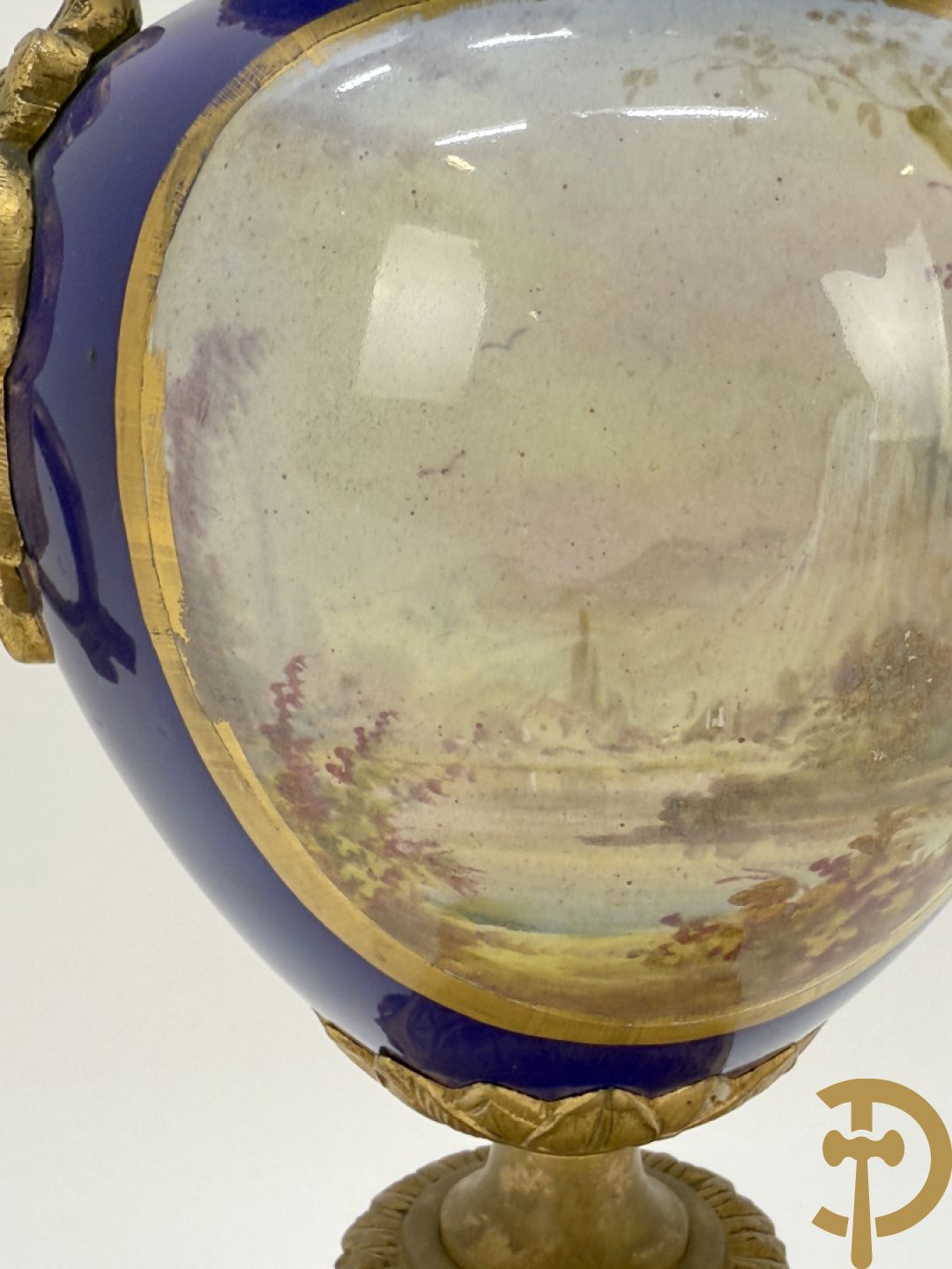 Driedelige vergulde bronzen garnituur bestaande uit pendule met blauw porseleinen coupe geflankeerd door 2 cupido