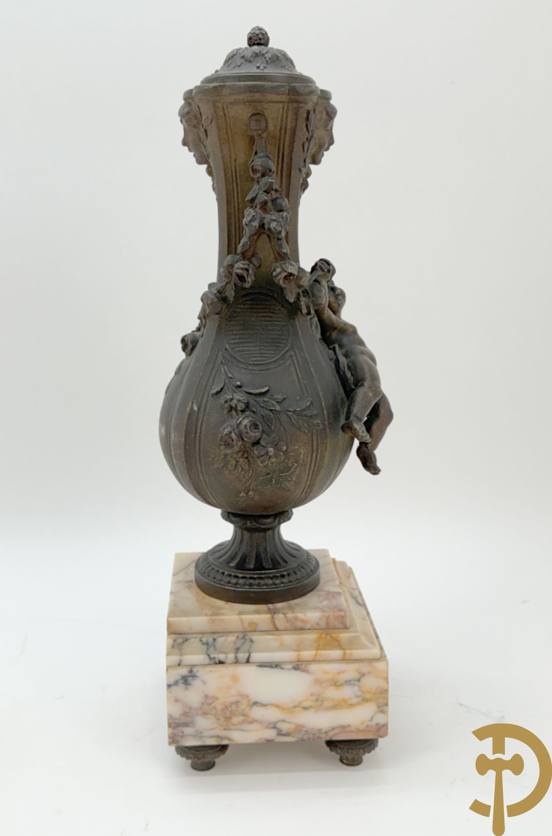 Driedelige kunstbronzen garnituur bestaande uit klok met liggende dame met amfoor op marmeren basis, geflankeerd door paar cassolettes met cupido