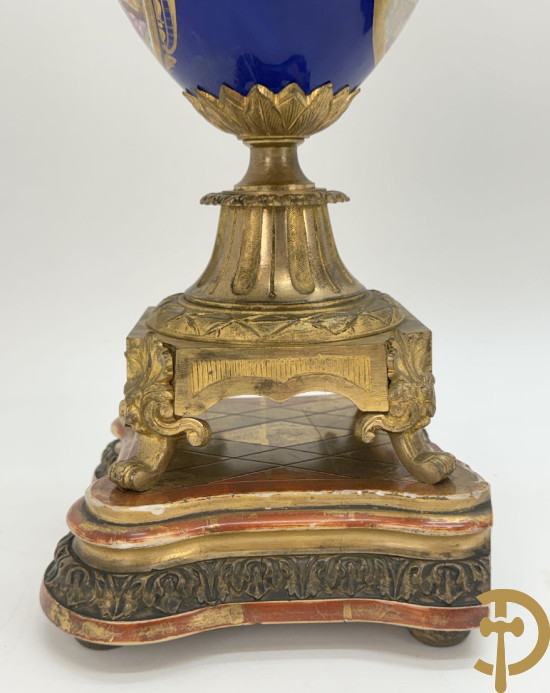 Driedelige vergulde bronzen garnituur bestaande uit pendule met blauw porseleinen coupe geflankeerd door 2 cupido