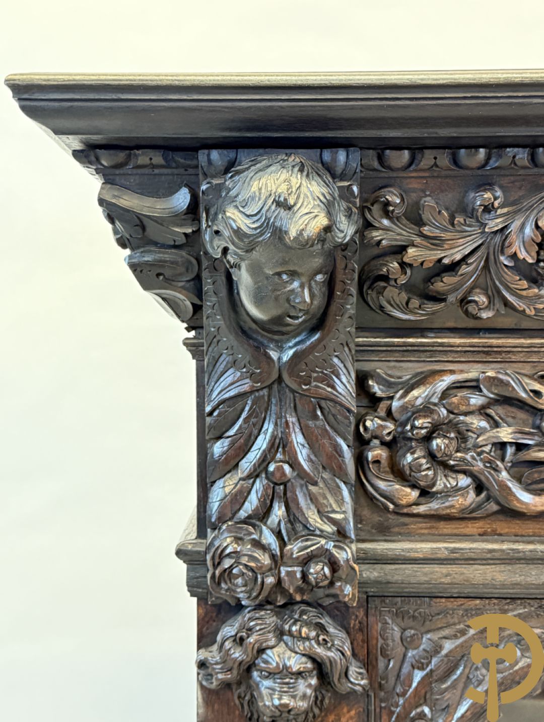 Tweedeursvitrine met Neo Renaissance sculptuur, bovenaan mlet cupidohoofden, bloemen en accanthusranken