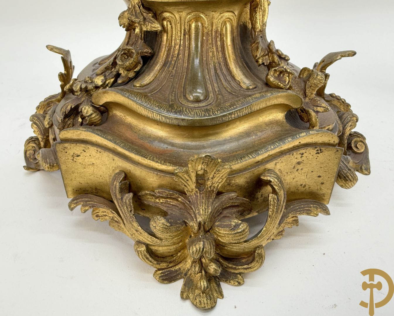Driedelige bronzen garnituur bestaande uit middenstuk met bronzen vuurvergulde klok, Daubrée gemerkt à Nancy, bovenaan bekroond met Cleopatra met drinkbeker - getekend van Cumberworth sculpteur - geflankeerd door paar cupido