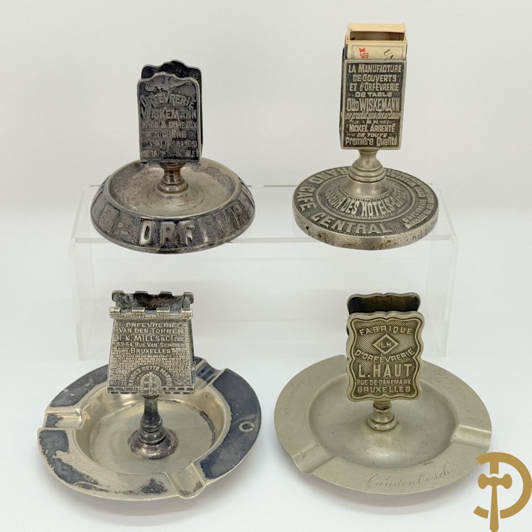Vier luciferhouders in verzilverd metalen met reclame opschriften van Wiskeman (2 x) , Orfeverie Van Den Torren en Orfeverie L. Haut
