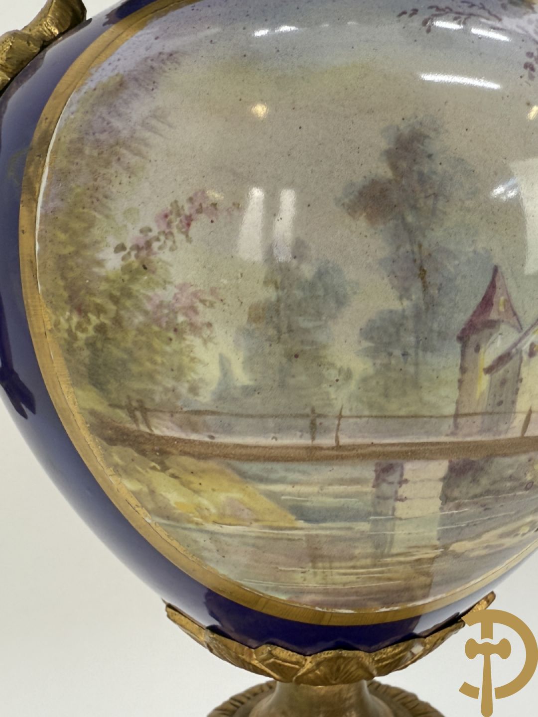 Driedelige vergulde bronzen garnituur bestaande uit pendule met blauw porseleinen coupe geflankeerd door 2 cupido