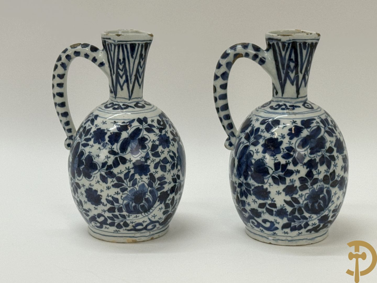 Twee Delftse blauw/wit schenkkannen met bloemendecor