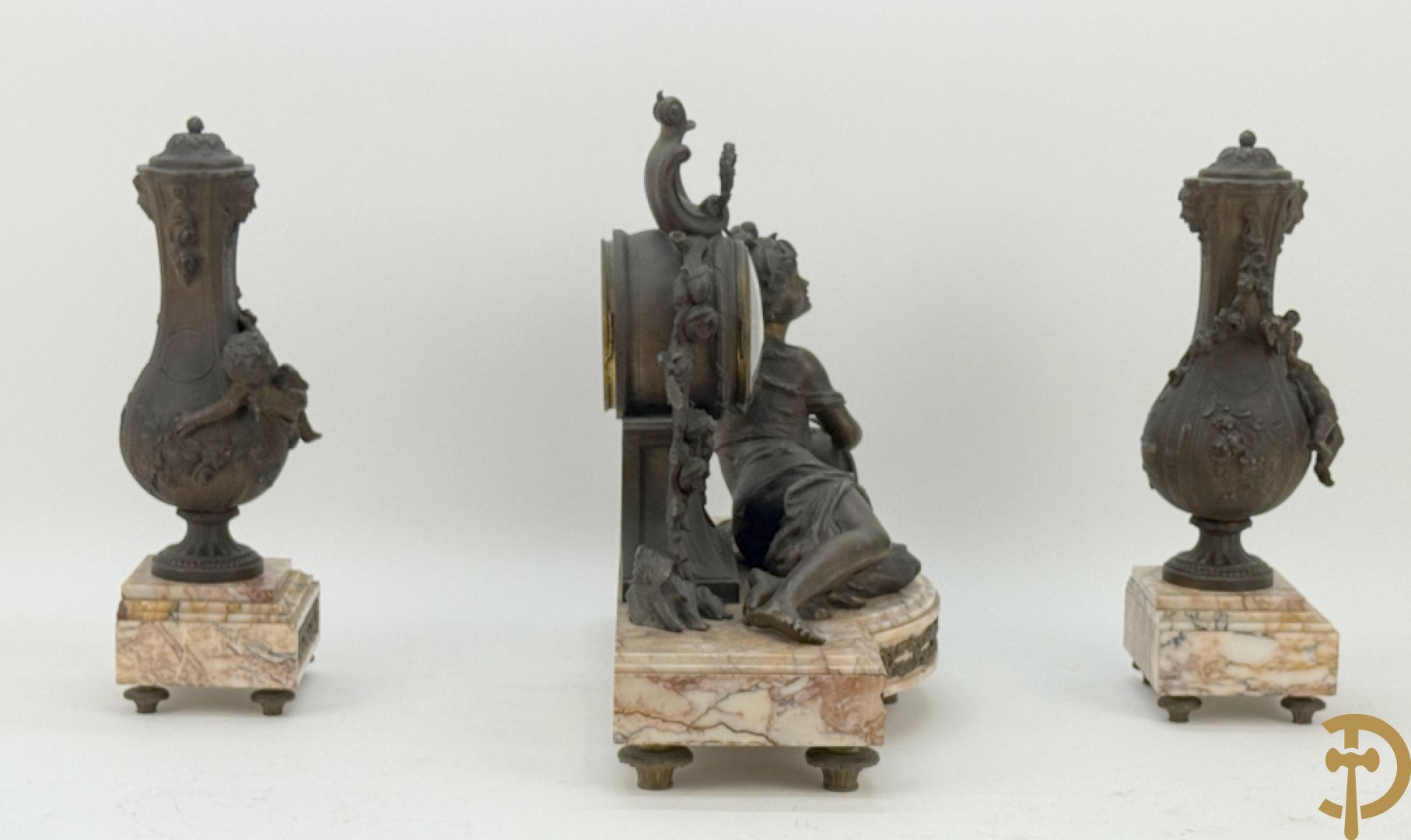 Driedelige kunstbronzen garnituur bestaande uit klok met liggende dame met amfoor op marmeren basis, geflankeerd door paar cassolettes met cupido