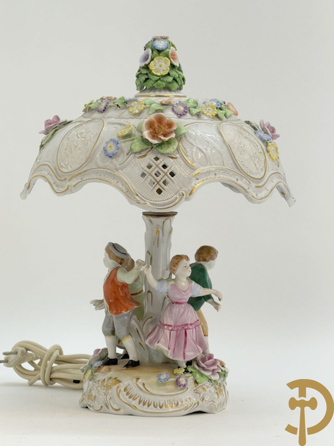 Porseleinen lampadaire met dansende figuren, bovenaan met porseleinen kap bezet met bloemmetjes