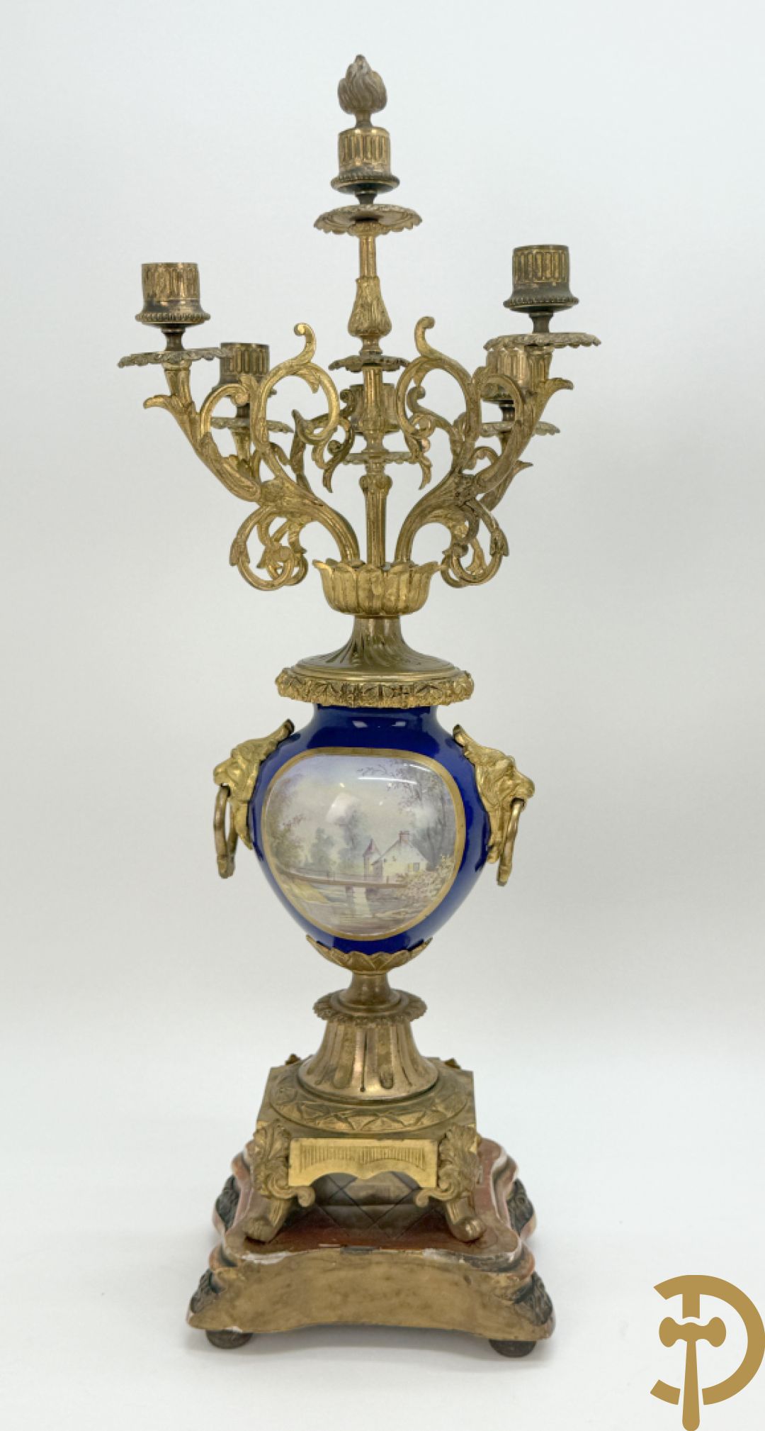 Driedelige vergulde bronzen garnituur bestaande uit pendule met blauw porseleinen coupe geflankeerd door 2 cupido