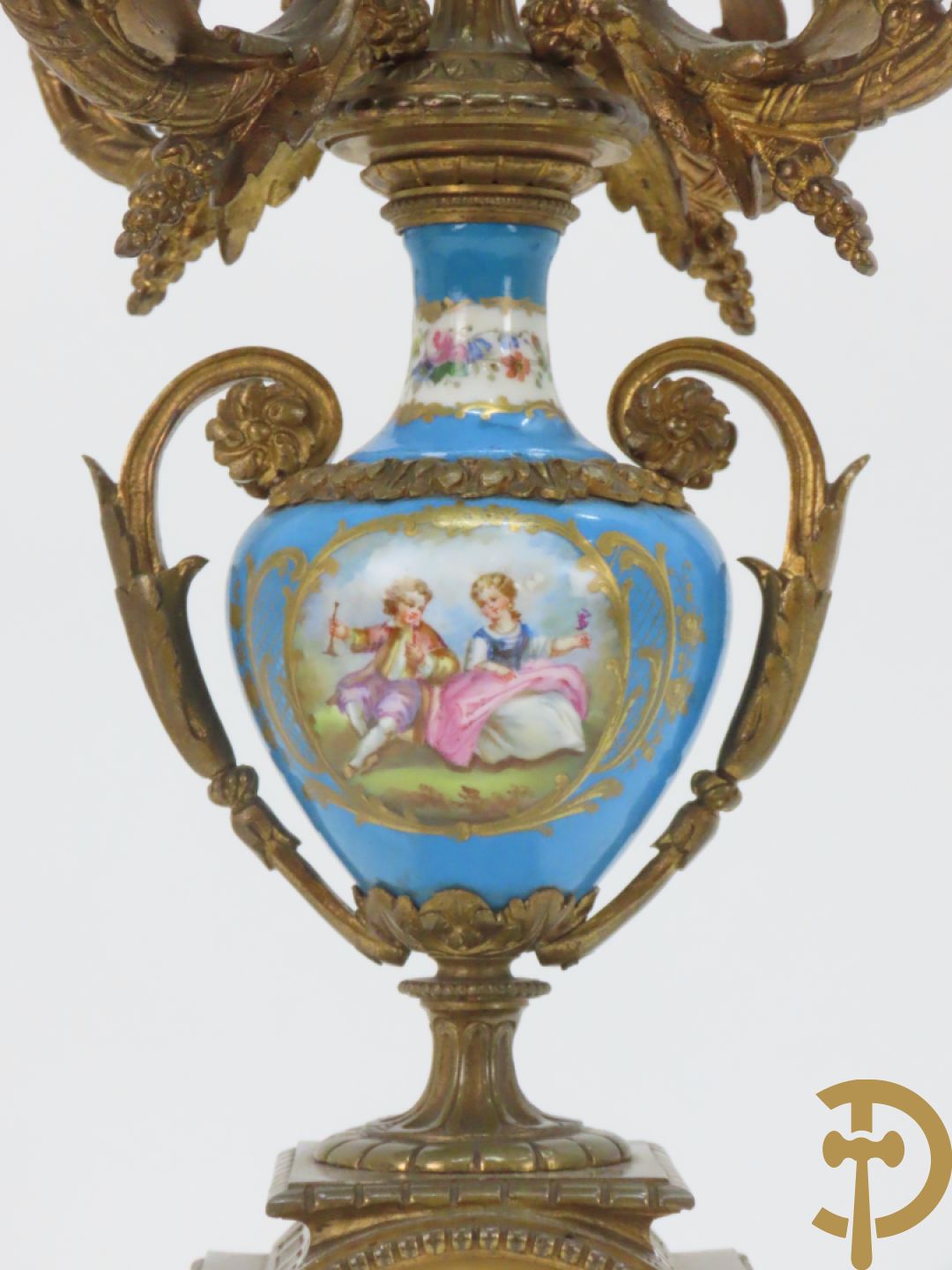 Driedelige bronzen garnituur bezet met Sèvres porselein bestaande uit pendule geflankeerd door paar cupido