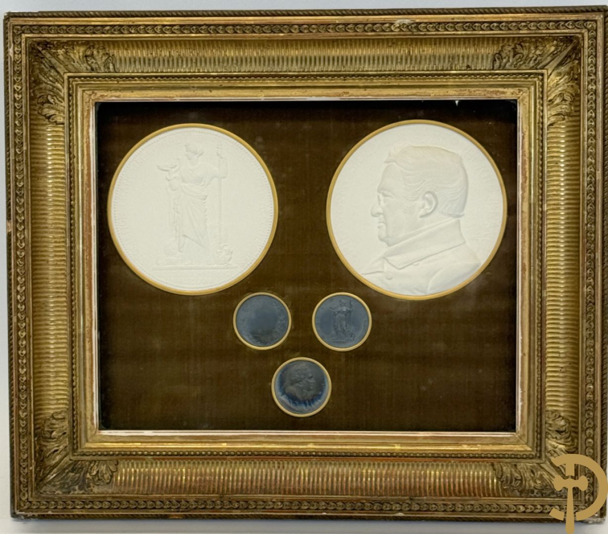 Kader met twee porseleinen plakkettes en 3 munten van Oudiné Eugène André