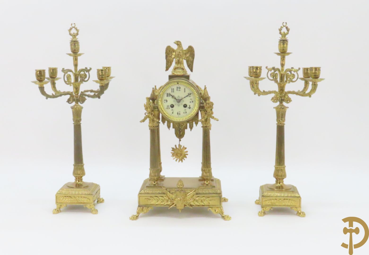 Driedelige bronzen garnituur bestaande uit middenstuk met 4 gecanneleerde zuilen en adelaar bezet + paar kandelaars