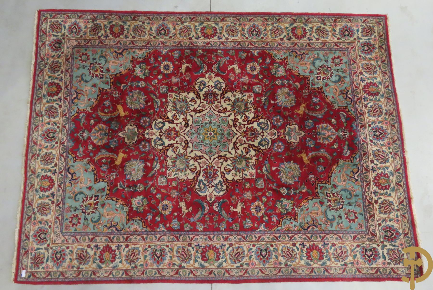 Oosters handgeknoopt tapijt met bloemen, dierenmotieven en centraal decor op rode fond