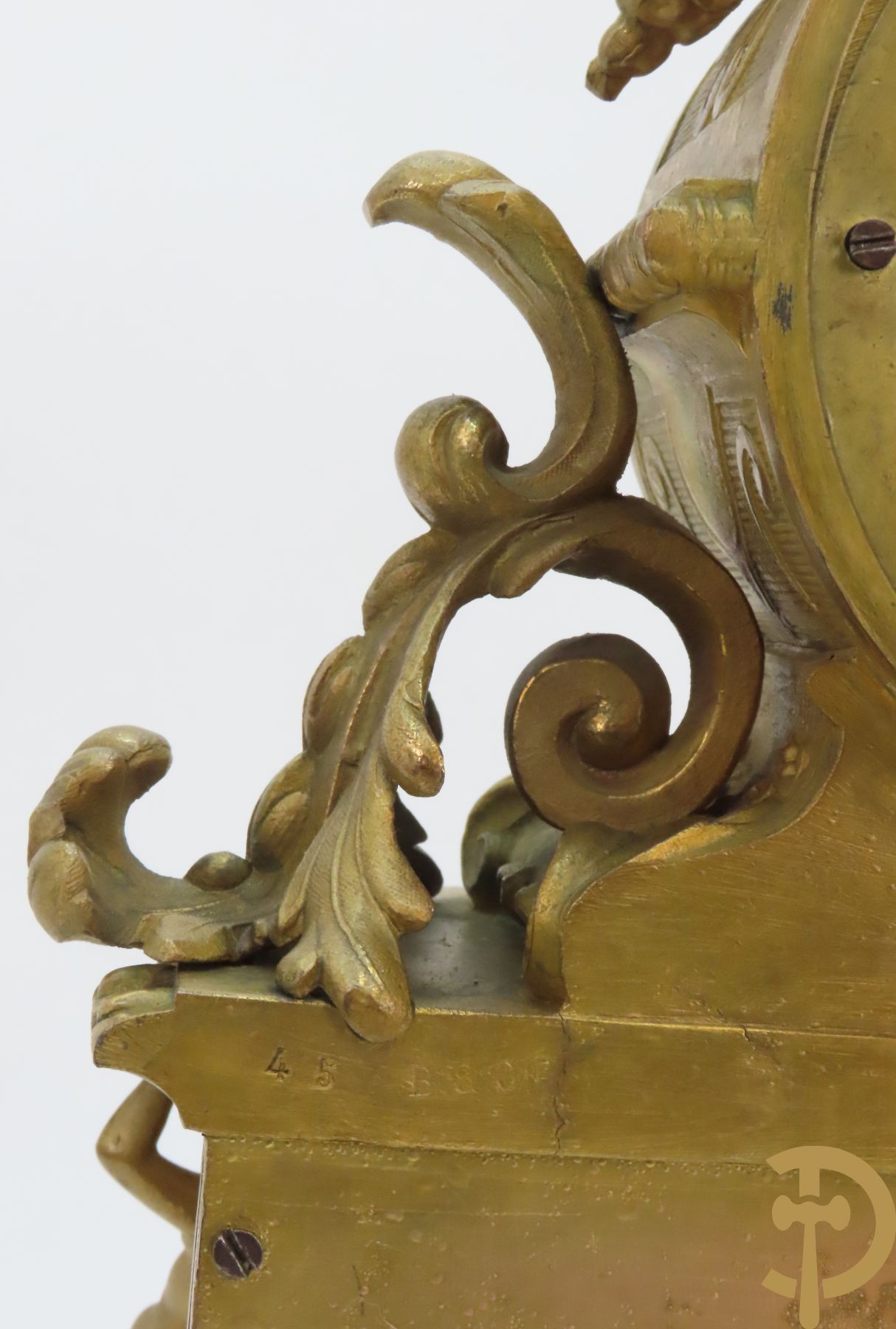 Vergulde pendule in zamak, wijzerplaat bezet met porseleinen plakkettes - bovenaan met vogelpaar, zijdelings met kariathyden houdende een bloementroffee - onder glazen stolp