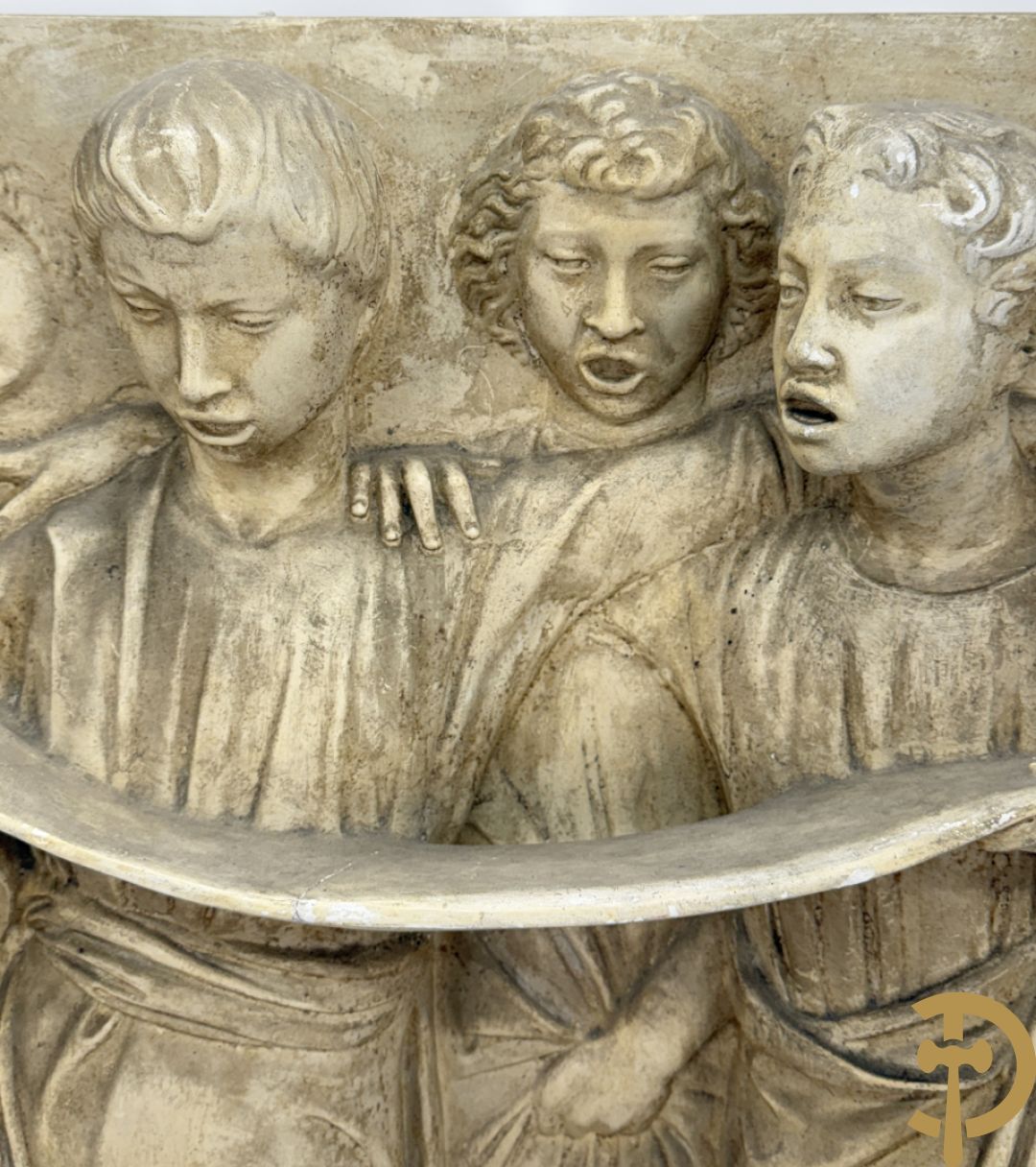 Gipsen basrelief met een zingend jongerenkoor