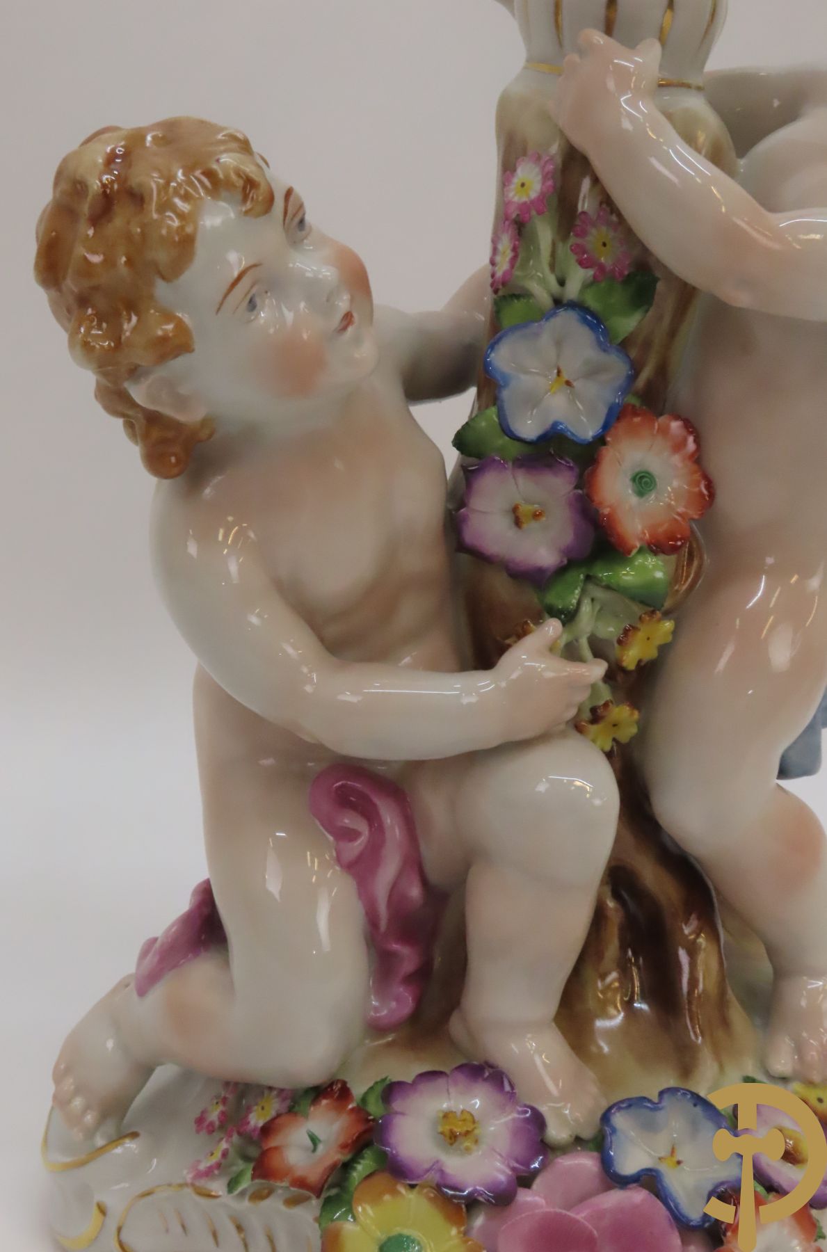 Twee porseleinen vijfarmige kandelaars met cupido