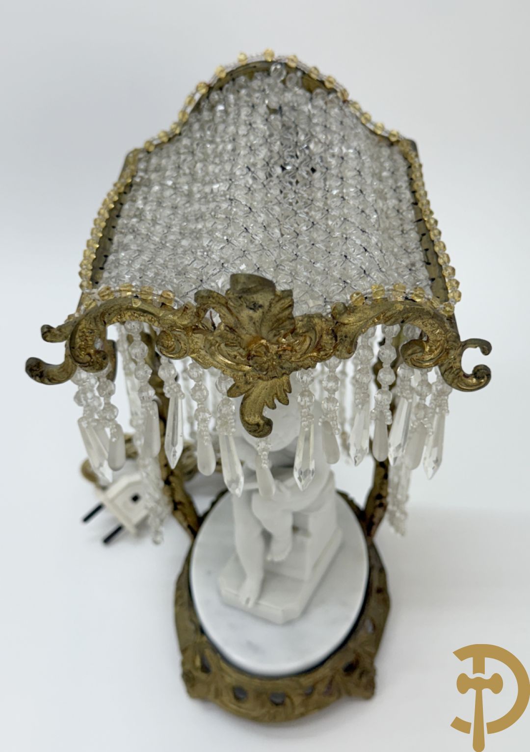 Biscuitbeeld van schrijvende cupido onder bronzen dakje met kristallen bellen bezet - op marmeren sokkel gemonteerd