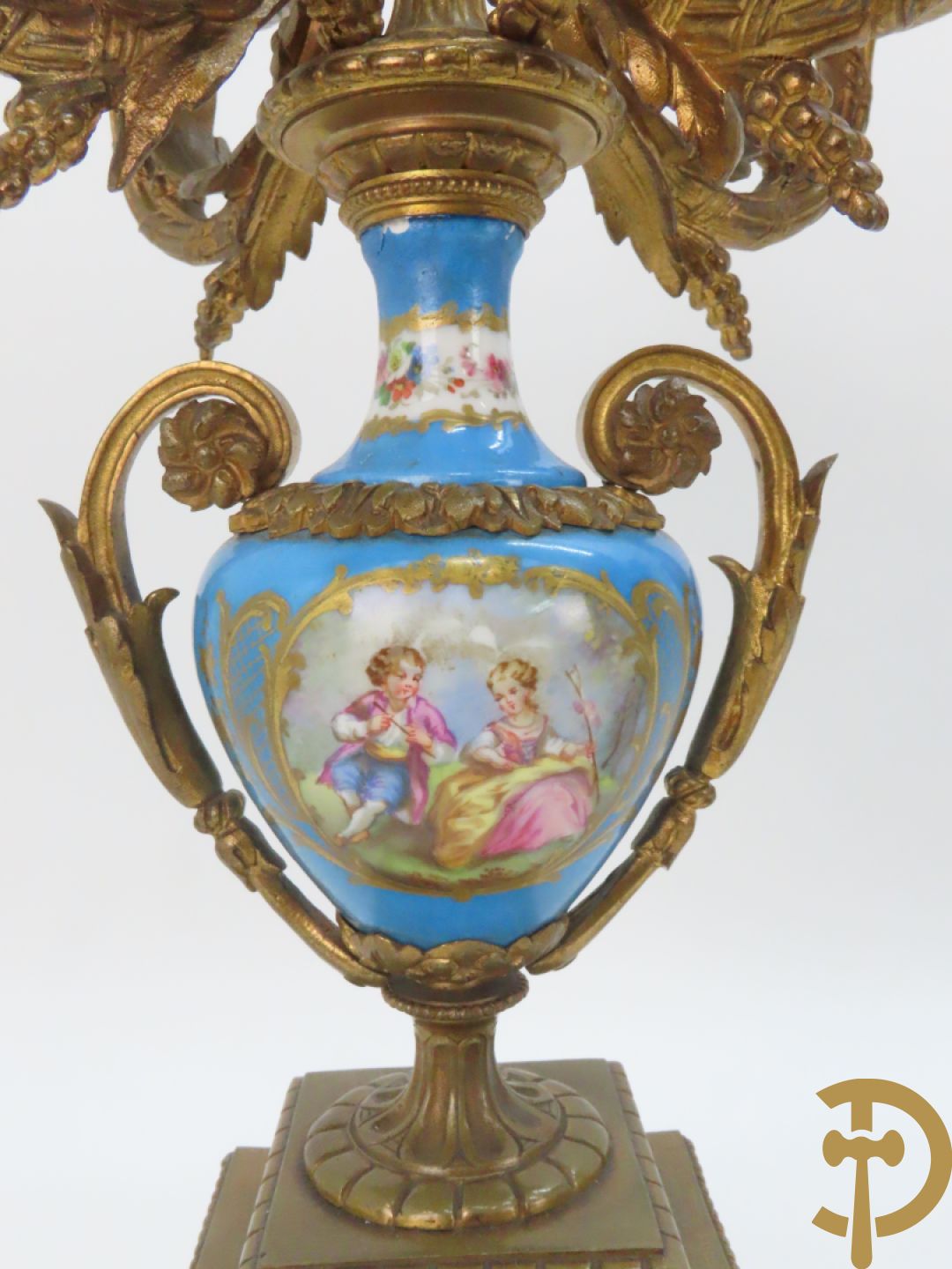 Driedelige bronzen garnituur bezet met Sèvres porselein bestaande uit pendule geflankeerd door paar cupido