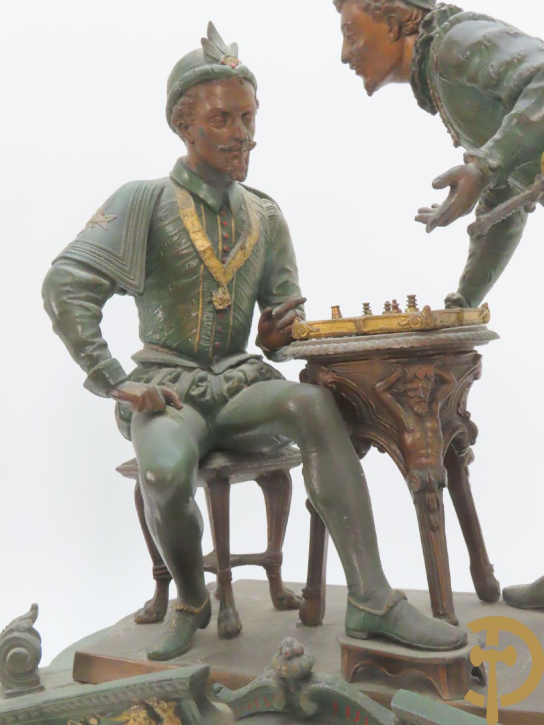 Driedelige kunstbronzen garnituur bestaande uit pendule met paar schakende edelheren, bezet met kariatiden - geflankeerd door paar driearmige kandelaars gehouden door 2 edelheren